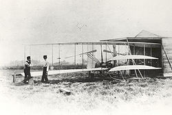 Airplane Picture - Orville(left) & Wilbur with the Wright Flyer II at Huffman Prairie May 1904. *note anemometer on strut behind Wilbur. photo possibly taken by Lorin Wright or Charlie Taylor