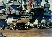 Airplane Pictures - USS Yorktown (CV-10) during the Marcus Island raid on 31 August 1943: CAG-5 Lt. Cmdr. Jimmy Flatley in his F6F-3 Hellcat before takeoff. Aviation Boatswain Mate stands ready to remove chock from wheels. Early, improvised scheme of non-specular sea-blue and intermediate blue over white